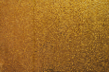Small gold tile texture. Small golden tiles arranged to fit it into background. Golden tiled...