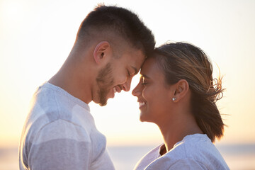 Couple, sunset forehead touch for love, outdoor beach date and happy holiday together. Man, woman and face of relationship at ocean for freedom, support and relax with trust, peace and smile of care