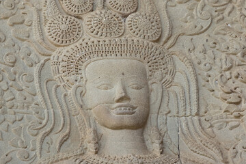 Fototapeta na wymiar Close up of an iconic APSARA bas-relief who shows her teeth with a smile in Angkor Wat of Siem Reap, Cambodia.