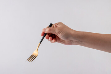 Hand and metal black fork on white background