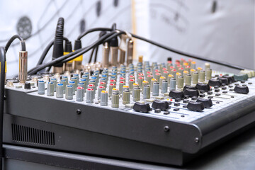A small mixing console with cables with jacks inserted into console