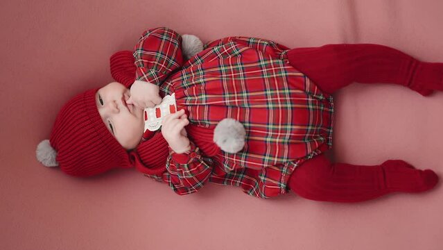 Adorable caucasian baby lying on floor with relaxed expression over isolated red background