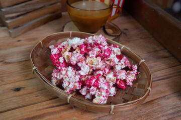 selective focus on popcorn dyed red in a bamboo basket, soft focus