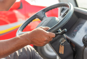 Man's hands on the steering wheel of a car.