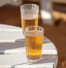 Two faceted glasses with beer on the table