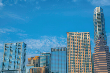 Fototapeta na wymiar Apartments and corporate buildings under the blue sky at Austin, Texas. Cityscape views with one building under construction in the middle.