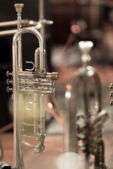 A silver plated trumpet with a mouthpiece standing behind a flugelhorn