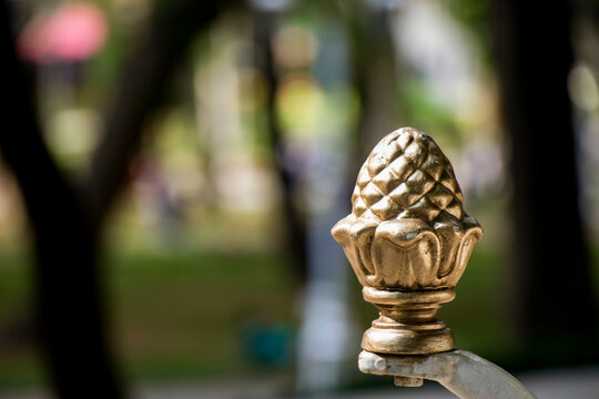 Bronze cone sculpture in relief in a park in an open area.