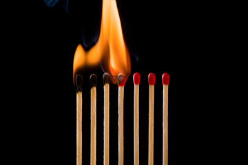Light a match next to a row of unlit matches. Matchsticks burn