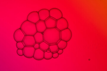 Nahaufnahme eines Haufens aus Seifenblasen vor rotem Hintergrund