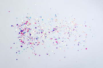 Pink, purple confetti glitter glitter scattered on a white background