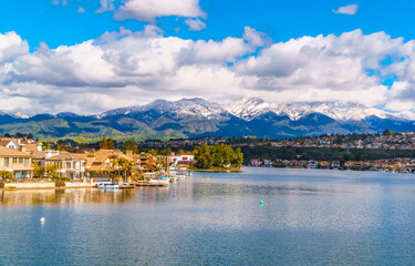 Fototapeta na wymiar Scenic Lake Mission Viejo with snow capped Santa Ana Mountains in the distance, after epic snowstorm in Southern California