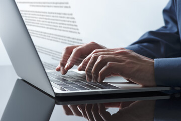 Writing business document. Business person using laptop. Close up of hands typing.