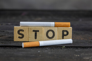 Cigarettes And Wooden Blocks Showing Stop Word On Desk