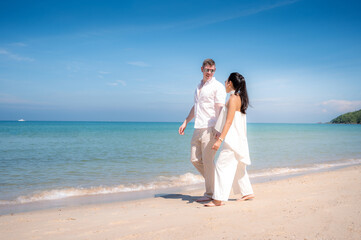 Fototapeta na wymiar happy couple jumping on the beach romantic moments in honeymoon trip.