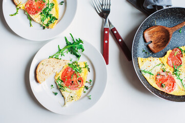 tasty italian style vegetarian breakfast - fried eggs frittata ot omelete with mozarella cheese, arugula and tomatoes