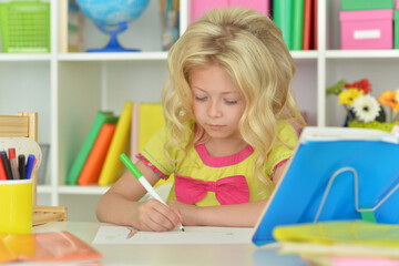 little girl studying at home at the table