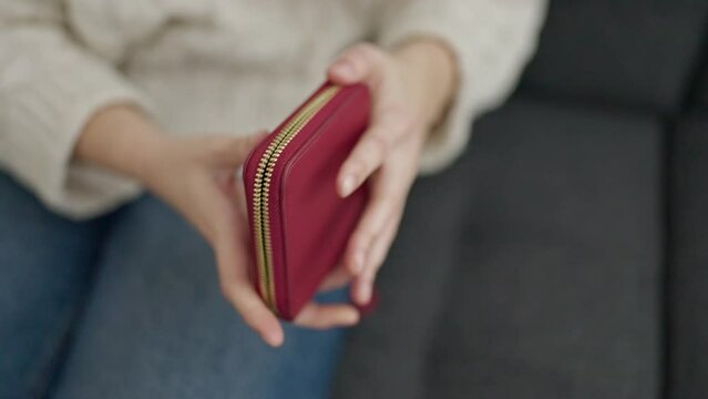 Young beautiful hispanic woman showing empty wallet at home