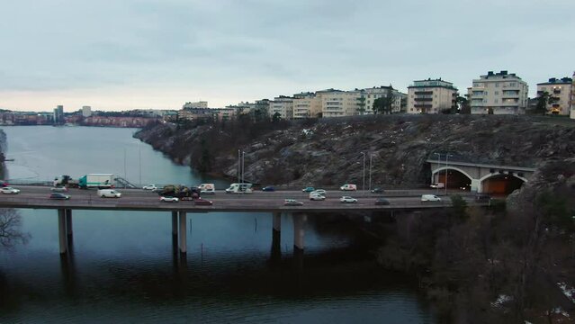 Stockholm freeway on winter cloudy day showing steady traffic. Aerial rise tilt down shot