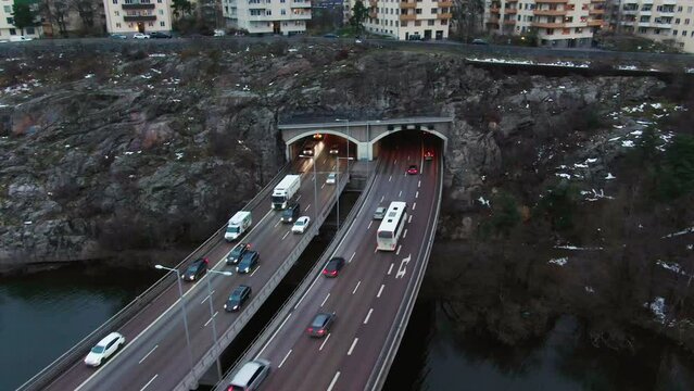 Parallaxing drone shot over Stockholm freeway tilt up towards skyline