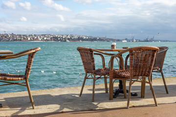 Fototapeta na wymiar Chairs and tables in a street cafe on the pier.