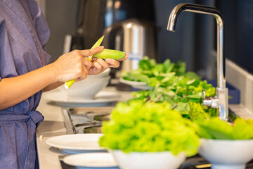 Woman is peeling green banana and preparing dinner for family.