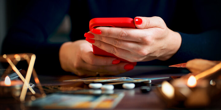 Future and online divination. A fortune teller does online fortune telling on photos from a smartphone.