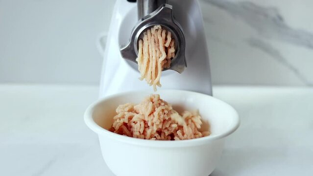 Cooking minced meat in an electric meat grinder from. The process of grinding meat in an electric meat grinder close-up. Kitchen appliances. Slow-motion