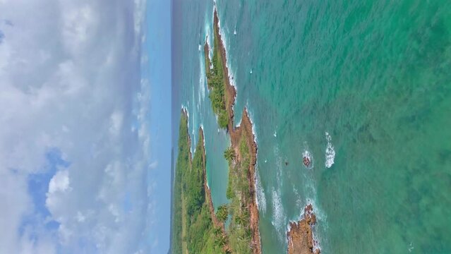 Aerial backward over Los Coquitos rocky coast, Cabrera in Dominican Republic. Vertical format