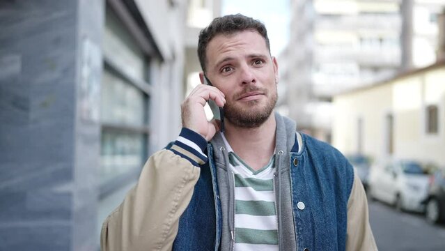 Young caucasian man speaking on the phone at street