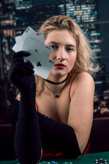 Young  woman holding playing cards aces at casino