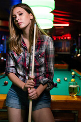 Portrait of beautiful young woman in billiard club