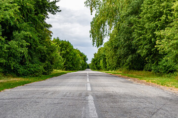 Beautiful empty asphalt road in countryside on colored background