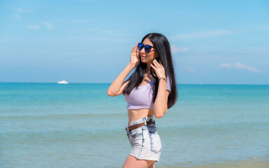 Summer lifestyle portrait of young girl enjoying on the tropical island. In the background the sea. Wearing Crop tops and shorts relaxed, Straight long hair.summer travel concept.