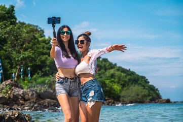 Lifestyle women and friends having fun and enjoying being themselves.Girls smiling and selfie with friends by the sea on the tropical island.Concept summer travel.