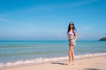 Summer lifestyle portrait of young girl enjoying on the tropical island. In the background the sea. Wearing Crop tops and shorts relaxed, Straight long hair.summer travel concept.