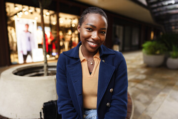 Portrait of smiling young black woman standing in the street