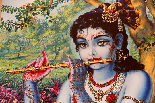 Painting depicting Hindu god Krishna playing a flute outdoors. India.