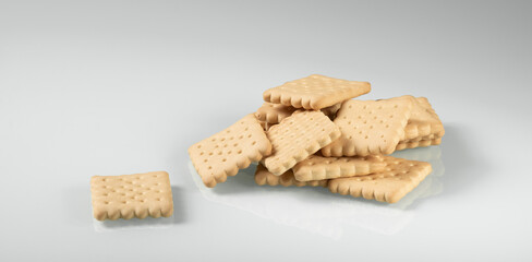 A pile of crackers carelessly scattered on a light background close-up