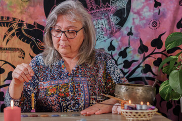 woman fortune teller with a pendulum on chakra stones
