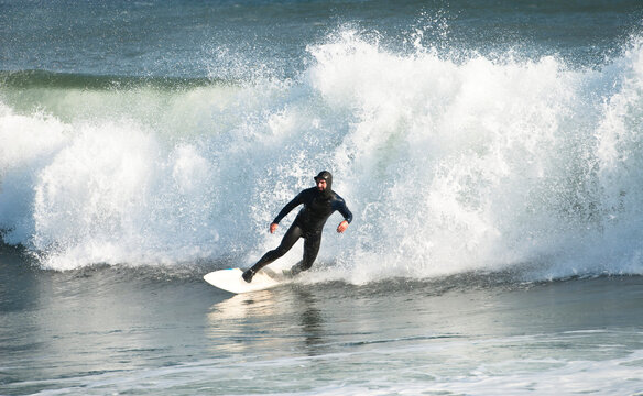Surfer in wetsuit riding wave