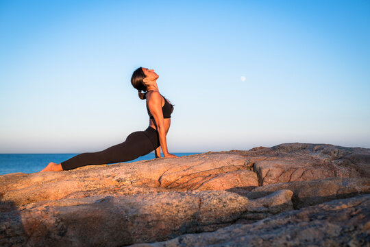 Woman doing yoga on seashore, Narragansett, Rhode Island, USA