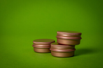 Pink cosmetic container on a green background