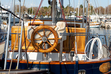 A very expensive wooden yacht in an Athens harbor. Wooden steering wheel.