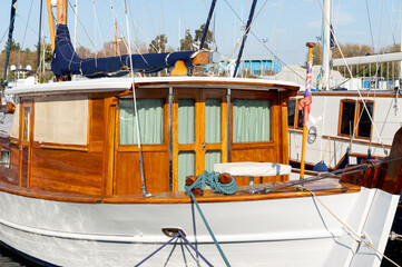 A very expensive wooden yacht in an Athens harbor. Wooden steering wheel.