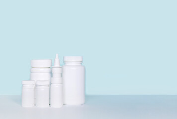 Set of various white medicines, mockup, pill bottles without label design, copy space on blue background	