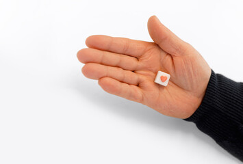 Sugar cube with red heart in hand on white background. medicine concept. diabetes concept