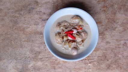 Sayur nangka is Indonesia vegetable soup made from young jackfruit, coconut milk. served in a bowl on a wooden table