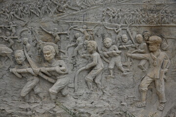 Fototapeta na wymiar Memorial shrine festooned with bas-reliefs of Khmer Rouge atrocities at Wat Somrong Knong. Cambodia.