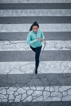 Young woman jogging on zebra crossing